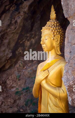 Statua dorata di Buddha su un crepaccio della roccia al Monte Phou si, a Luang Prabang, Laos. Foto Stock