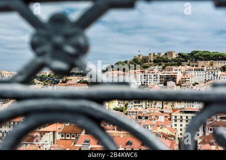 Europa, Portogallo, capitale, città vecchia di Lisbona, punto di vista, vista della rovina Castelo de Sao Jorge sulla collina del castello, visto attraverso la balaustra di metallo in primo piano Foto Stock