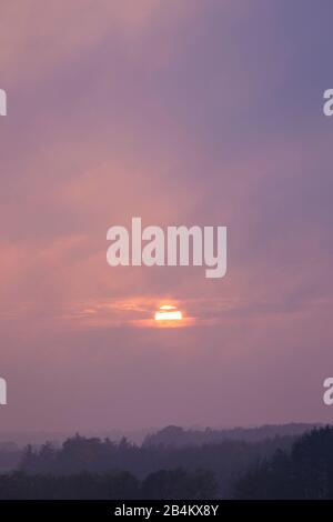 Europa, Danimarca, Bornholm. Tramonto nebbioso e coperto di nubi su Bornholm sud. Foto Stock