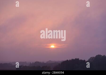 Europa, Danimarca, Bornholm. Tramonto nebbioso e coperto di nubi su Bornholm sud. Foto Stock