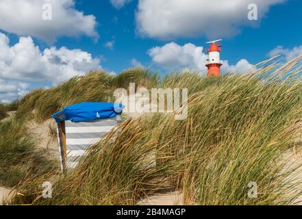 Germania, Bassa Sassonia, Mare del Nord, Isole Frisone Orientali, Parco Nazionale del Mare di Wadden, Borkum, tenda da spiaggia nelle dune sulla spiaggia sud con faro Foto Stock