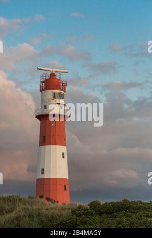 Germania, Bassa Sassonia, Mare del Nord, Isole Frisone Orientali, Parco Nazionale del Mare di Wadden, Borkum, faro elettrico nelle dune al tramonto Foto Stock