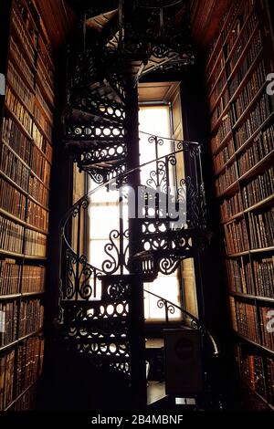 Scala a spirale artisticamente forgiata in controluce nella biblioteca del Trinity College di Dublino, Irlanda Foto Stock