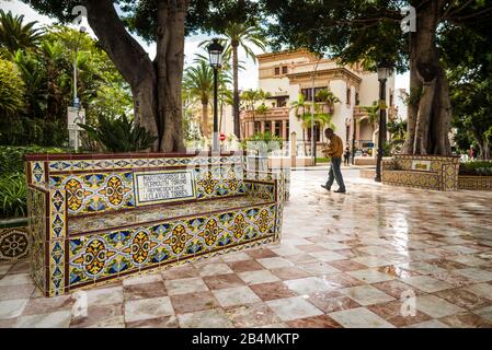 Spagna Isole Canarie Tenerife Island, Santa Cruz de Tenerife, Plaza 25 de Julio, nei primi anni del XX secolo park con panchine coperte in pubblicità antichi fatti di piastrelle azulejo Foto Stock