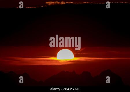 Tramonto di Crimson dietro le montagne Wetterstein, fotografato dal Karwendel. Foto Stock