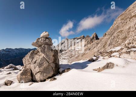 Un Steinmandl come segnavia sulla salita a Laliderspitze nell'Akrwendel. Sullo sfondo il Ladiztürme e il Sonnenspitze. Foto Stock