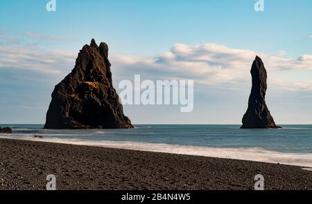 Islanda, Reynisfjara, spiaggia di sabbia nera, vette del mare di Reynisdrangar Foto Stock