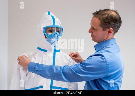 Lussemburgo, Lussemburgo. 06th Mar, 2020. Il product manager Albrecht Gerland sta adattando la tuta protettiva di un manichino in un impianto del gruppo di prodotti chimici speciali USA-americani Dupont. L'azienda DuPont produce il non tessuto Tyvenk, da cui vengono realizzati i vestiti protettivi. La domanda è aumentata vertiginosamente a livello mondiale con la crescente diffusione del nuovo coronavirus. Credito: Oliver Dietze/Dpa/Alamy Live News Foto Stock