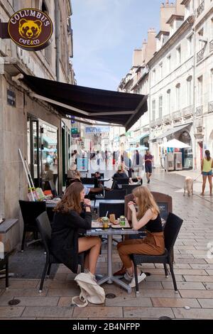 Due adolescenti chiacchierano nel bar della strada. Scena di strada nella città vecchia di Besançon. Una città nell'est della Francia. Dipartimento del Doubs. Foto Stock