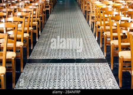 Pavimento a mosaico con gigli araldici fiancheggiati da file di sedie nella chiesa di San Martino a Villers sur Mer. Una località balneare nella regione della Normandia nel dipartimento del Calvados. Foto Stock