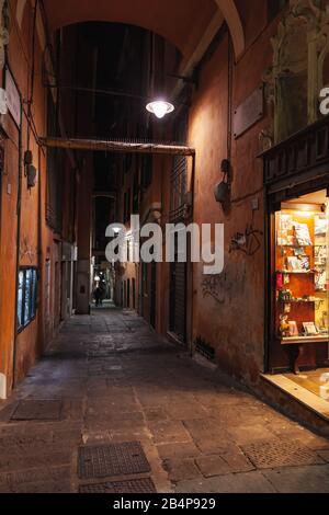 Genova, Italia - 17 gennaio 2018: Vista su una strada stretta di Genova di notte, vetrine illuminate Foto Stock