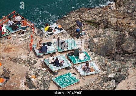 Busan, Corea del Sud - 18 marzo 2018: Le persone mangiano in un ristorante di pesce all'aperto sulle rocce costiere del parco naturale Taejongdae Foto Stock