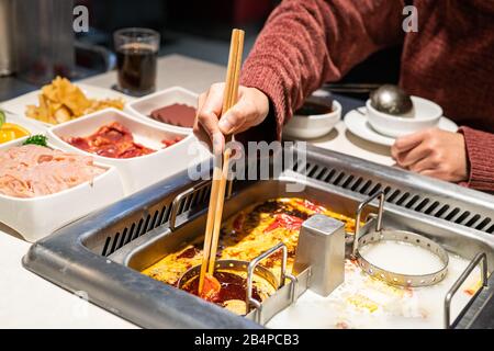 Zuppa cinese di shabu speziata e acida con carne e frutti di mare, stile cinese Suki - fuoco selettivo Foto Stock