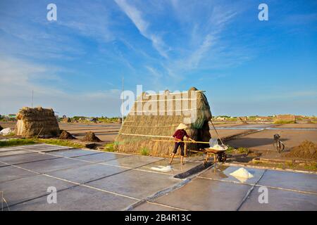 BACH LONG, GIAO THUY, NAMDINH, VIETNAM - 10 LUGLIO 2016: Una donna locale non identificata che lavora sui campi di sale. Questa è una delle più grandi produzioni di sale Foto Stock