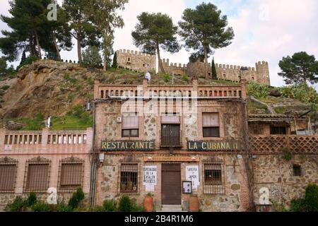 Ristorante la Cubana nella città vecchia di Toledo, Spagna. Edificio in mattoni d'epoca, chiuso con il Castello di San Servando sopra sulla collina. Foto Stock