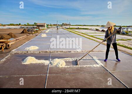 BACH LONG, GIAO THUY, NAMDINH, VIETNAM - 10 LUGLIO 2016: Una donna locale non identificata che lavora sui campi di sale. Questa è una delle più grandi produzioni di sale Foto Stock