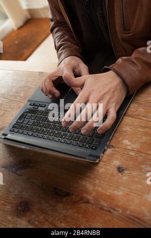 Un uomo la digitazione sul suo computer portatile Foto Stock