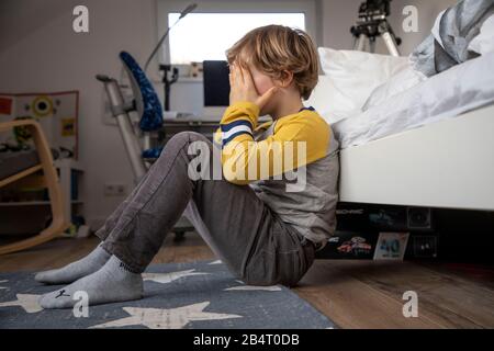 Bambino con mal di testa, ragazzo di 9 anni, con dolore viso distorto, immagine simbolica, Foto Stock