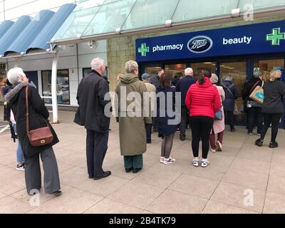 La gente fila fuori di un negozio di farmacia Boots nella zona ovest di Londra dove le scorte di igienizzatore per le mani sono limitate a due per persona. Foto Stock