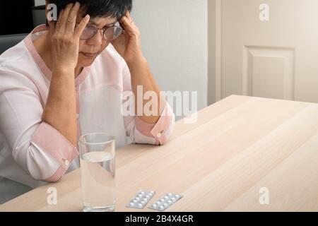 Vecchia donna che soffre di mal di testa e stress, emicrania, problema di salute concetto Foto Stock