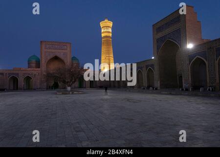 Cortile interno della Moschea Kalyan, parte del complesso po-i-Kalyan e illuminato Kalon Minareto di notte, Bukhara, Uzbekistan Foto Stock