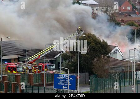 Belfast, Irlanda Del Nord. 7th Mar 2020. Gli equipaggi dei servizi antincendio dell'Irlanda del Nord affrontano un grande incendio presso il Trinity Lodge a Belfast ovest, sabato, marzo 7th, 2020. Il tetto sulla parte posteriore collassato molto rapidamente ha questi insieme delle immagini mostrano. Photo/Paul Mcerlane Credit: Paul Mcerlane/Alamy Live News Foto Stock