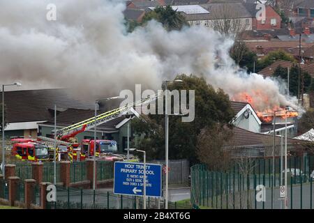 Belfast, Irlanda Del Nord. 7th Mar 2020. Gli equipaggi dei servizi antincendio dell'Irlanda del Nord affrontano un grande incendio presso il Trinity Lodge a Belfast ovest, sabato, marzo 7th, 2020. Il tetto sulla parte posteriore collassato molto rapidamente ha questi insieme delle immagini mostrano. Photo/Paul Mcerlane Credit: Paul Mcerlane/Alamy Live News Foto Stock