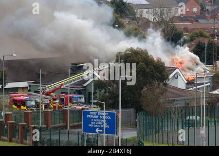 Belfast, Irlanda Del Nord. 7th Mar 2020. Gli equipaggi dei servizi antincendio dell'Irlanda del Nord affrontano un grande incendio presso il Trinity Lodge a Belfast ovest, sabato, marzo 7th, 2020. Il tetto sulla parte posteriore collassato molto rapidamente ha questi insieme delle immagini mostrano. Photo/Paul Mcerlane Credit: Paul Mcerlane/Alamy Live News Foto Stock