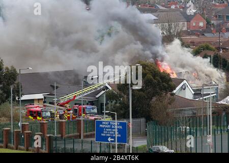 Belfast, Irlanda Del Nord. 7th Mar 2020. Gli equipaggi dei servizi antincendio dell'Irlanda del Nord affrontano un grande incendio presso il Trinity Lodge a Belfast ovest, sabato, marzo 7th, 2020. Il tetto sulla parte posteriore collassato molto rapidamente ha questi insieme delle immagini mostrano. Photo/Paul Mcerlane Credit: Paul Mcerlane/Alamy Live News Foto Stock