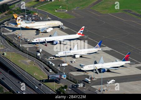 Più aeromobili a lunga percorrenza con cassone largo parcheggiati presso il piazzale dell'aeroporto internazionale. Aerei visibili di Boeing e Airbus. Aeroporto Di Sydney In Australia. Foto Stock