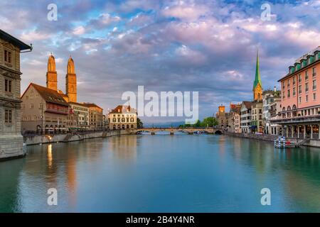 Famose chiese Fraumunster, Grossmunster e Wasserkirche lungo il fiume Limmat all'alba nel centro storico di Zurigo, la città più grande della Svizzera Foto Stock