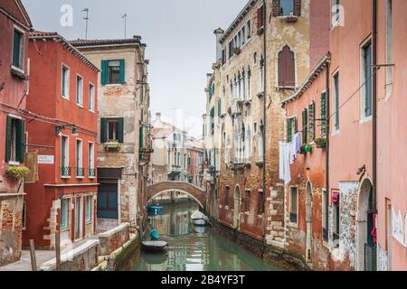 Un canale fiancheggiato da case e appartamenti nel quartiere residenziale di Venezia Foto Stock