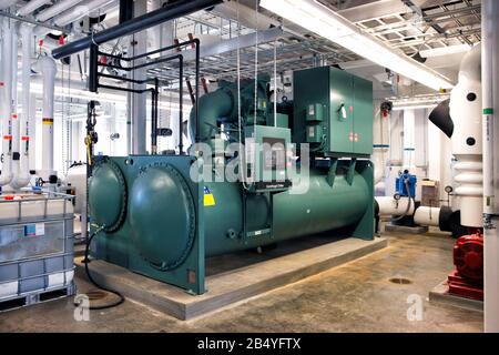 Un'unità condensatore industriale di grandi dimensioni per un refrigeratore in un sistema HVAC. Foto Stock
