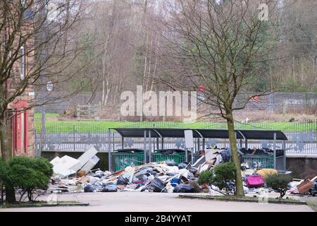 Volare rifiuti di ribaltamento a sinistra in derelict sviluppo di alloggi che causano l'inquinamento Foto Stock
