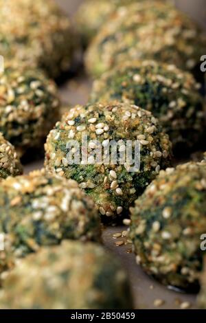 Polpette di ricotta e spinaci cotti in forno con pangrattato e sesamo. Foto Stock