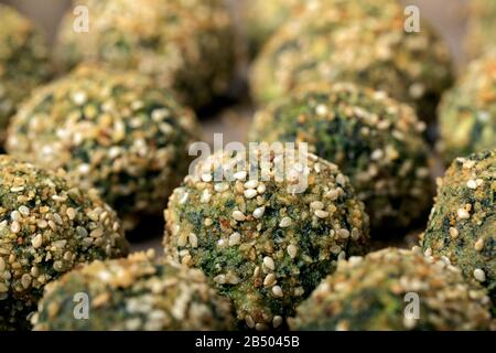 Polpette di ricotta e spinaci cotti in forno con pangrattato e sesamo. Foto Stock