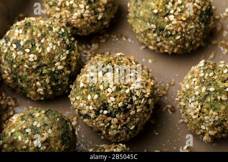 Polpette di ricotta e spinaci cotti in forno con pangrattato e sesamo. Foto Stock