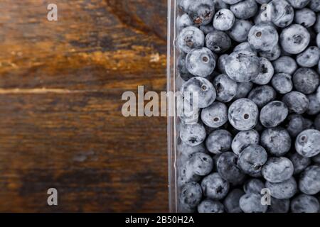 Mirtilli freschi in un contenitore di plastica. Concetto di alimentazione sana e dieta. Foto Stock