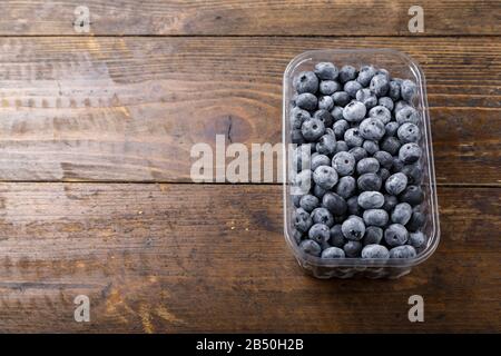 Mirtilli freschi in un contenitore di plastica. Concetto di alimentazione sana e dieta. Foto Stock