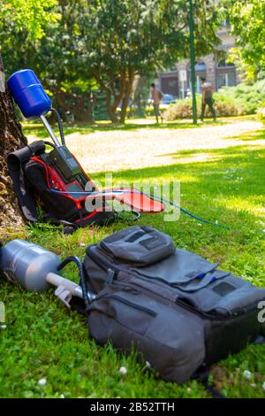 L'Equopment di un equipaggio di notizie in un parco lasciato sull'erba mentre prende l'intervista pronta per la trasmissione dal vivo Foto Stock