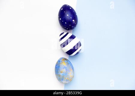 Buona Pasqua. Cornice per testo fatto di uova di pasqua alla moda colore classico blu, bianco e oro su blu. Stile minimo, vista dall'alto, appiattimento, spazio di copia. Foto Stock