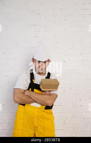 Un pittore professionista compatto e pronto a lavorare in qualsiasi momento. Indossa i tipici indumenti protettivi utilizzati nel cantiere. Foto Stock