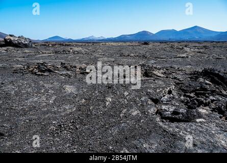 Ampi campi di lava che offrono un caratteristico paesaggio lunare nel Parco Nazionale di Timanfaya, Lanzarote Foto Stock