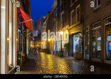 Leiden, Olanda, Paesi Bassi, 16 Gennaio 2020. La vista notturna delle biciclette parcheggiate tutto intorno, ponti, strade, canali, caffè, chiatte nella città vecchia, barca Foto Stock