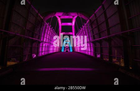 i luminosi led viola illuminano il passaggio pedonale sull'autostrada di notte Foto Stock