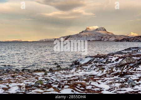 Paesaggio tundra ghiacciato con mare verde freddo e neve montagna Sermitsiaq sullo sfondo, vicino Nuuk città, Groenlandia Foto Stock