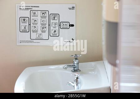 Una guida di lavaggio a mano in un bagno pubblico nel Brighton General Hospital, East Sussex, Regno Unito. Foto Stock