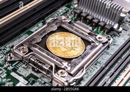 Cryptodurency Bitcoin dorato sulla scheda a circuito stampato del computer. Blockchain e concetto di sicurezza Foto Stock