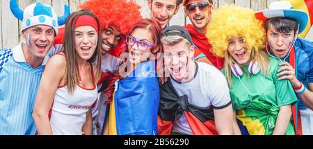 Gruppo di simpatici sostenitori dello sport che si divertono durante la partita di calcio - giovani tifosi che festeggiano fuori dallo stadio prima della partita di calcio - Friendship and Foto Stock