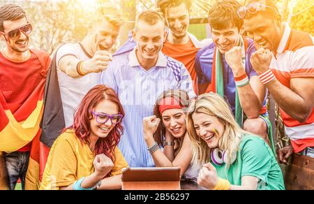 Amici dello sport felici tifosi che guardano partita di calcio su tablet all'aperto - giovani tifosi che celebrano un obiettivo - amicizia, calcio, calcio, e vincere c Foto Stock